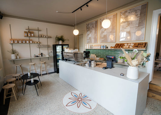 KALA, en indbydende kaffebar med en farverig blomst på gulvet, perfekt til babyshowers og sociale sammenkomster.