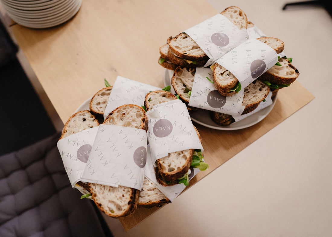 En indbydende bordopdækning med sandwiches fra KALA, perfekt til en hyggelig sammenkomst.