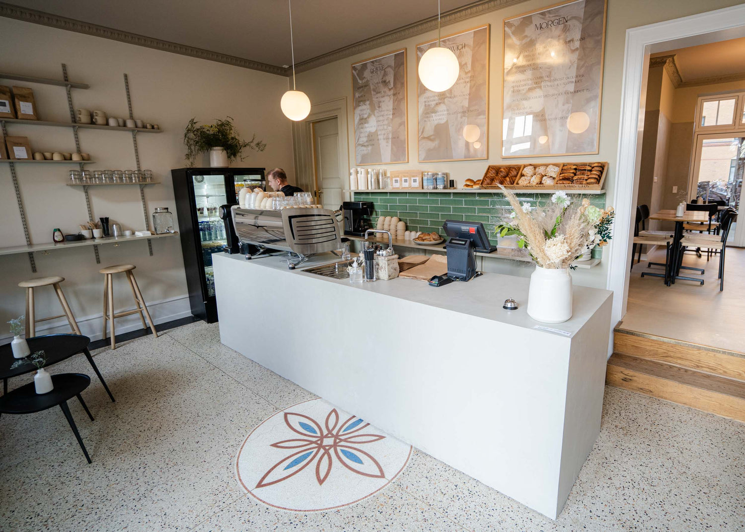 KALA, en indbydende kaffebar med en farverig blomst på gulvet, perfekt til babyshowers og sociale sammenkomster.