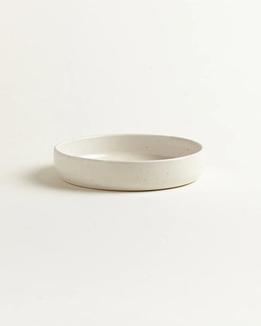 Hvid skål med en lille uddybning i midten, der giver et unikt og interessant design.