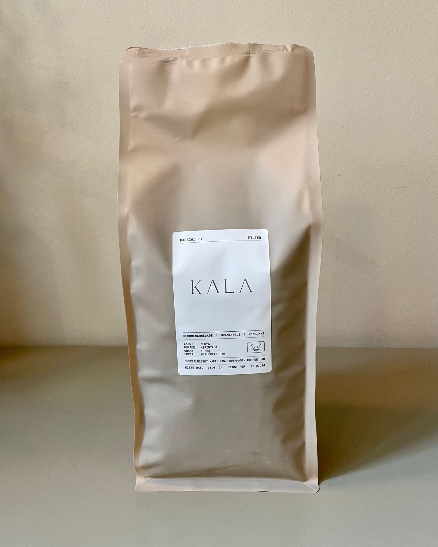 KALA filter kaffepose fra Copenhagen Coffee lab på et bord med minimalistisk logo i grønt, der udstråler elegance og skandinavisk stil.